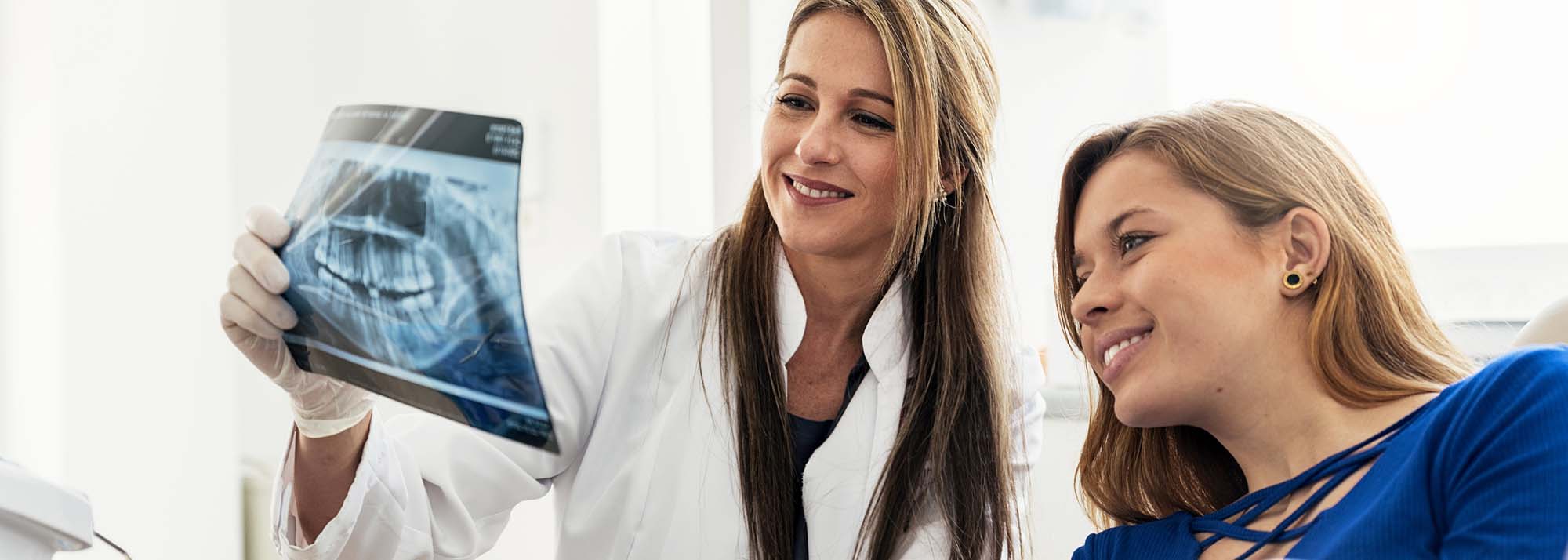 Doctor Talking With Her Patient And Teaching A Radiography.