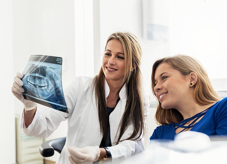 Doctor Talking With Her Patient And Teaching A Radiography.