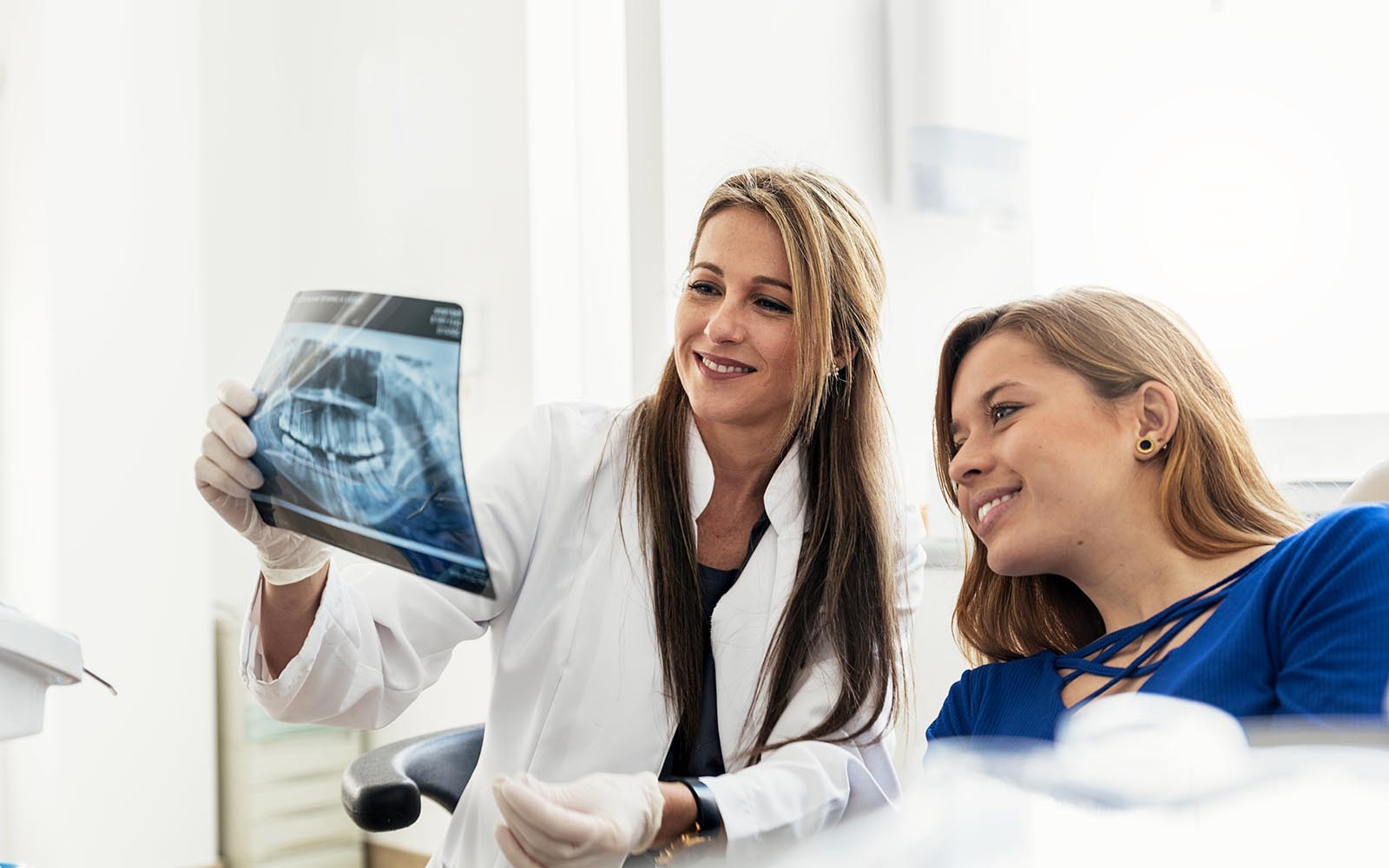 Doctor Talking With Her Patient And Teaching A Radiography.